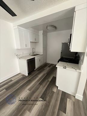 Hawthorne apartment for rent - an open kitchen with hardwood floors and white cabinets